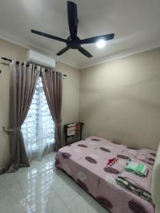 een slaapkamer met een bed en een plafondventilator bij Zahani Homestay in Kuala Terengganu