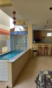 a large swimming pool in a house with a kitchen at Solar de Manguinhos Flat in Manguinhos