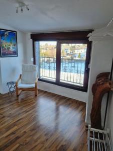 ein Wohnzimmer mit einem Stuhl und einem großen Fenster in der Unterkunft Wohlfühlende Wohnung nähe Dortmund in Witten