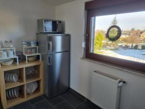 uma cozinha com um frigorífico de aço inoxidável e uma janela em Wohlfühlende Wohnung nähe Dortmund em Witten