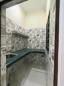 Łazienka z umywalką i ścianą wyłożoną kafelkami w obiekcie SHREE JI HOMESTAY w mieście Rishikesh
