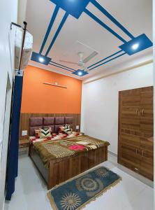 sypialnia z dużym łóżkiem z pomarańczową ścianą w obiekcie SHREE JI HOMESTAY w mieście Rishikesh