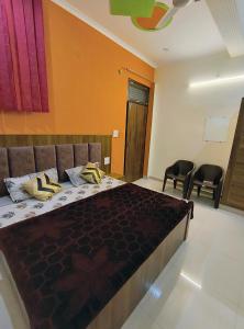 duże łóżko w pokoju z 2 krzesłami w obiekcie SHREE JI HOMESTAY w mieście Rishikesh