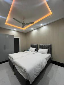 um quarto com uma grande cama branca e um tecto em Kharian-Inn Hotel em Khāriān