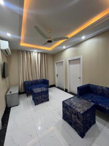 sala de estar con sofás azules y techo en Kharian-Inn Hotel en Khāriān