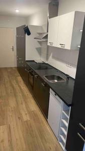 a kitchen with a black counter and white cabinets at Apartment in Langenhagen-Airport-Hannover! contactless check-in in Hannover