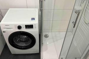 a washing machine in a bathroom next to a shower at Apartment in Langenhagen-Airport-Hannover! contactless check-in in Hannover