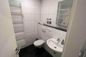 a white bathroom with a toilet and a sink at Apartment in Langenhagen-Airport-Hannover! contactless check-in in Hannover