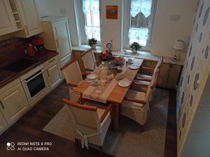 a kitchen with a wooden table and chairs at Ferienwohnung "Harzliebe" - FeWo in Quedlinburg OT Gernrode im Harz in Gernrode - Harz