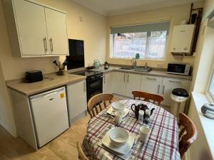 a small kitchen with a table and a table and chairs at Large Ground floor apartment in the heart of Church Stretton with free parking in Church Stretton