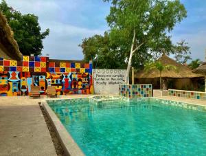 a swimming pool in front of a colorful fence at La Maison Chocolat in Nianing