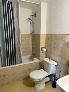 a bathroom with a toilet and a tub and a sink at AUX GLOBE-TROTTERS in Murat