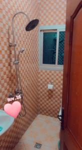 een badkamer met een douche met een hart aan de muur bij RESIDENCE LUXUEUSE BANGANGTE in Bangangté