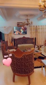 een woonkamer met een stoel en een tafel met een laptop bij RESIDENCE LUXUEUSE BANGANGTE in Bangangté