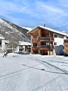 two people skiing in the snow in front of a building at Nanisgarten - Grannys flat in Obergesteln