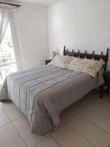 Cama en habitación blanca con ventana grande en Departamentos Alto Mendoza, en Las Heras 10 fotos más