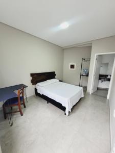 a bedroom with a bed and a desk and a piano at Mimos Hospedagem in São Paulo