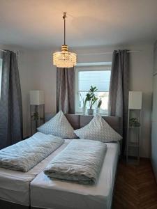 een slaapkamer met 2 bedden en een kroonluchter bij Ferienwohnung Allgäu 2 in Memmingen