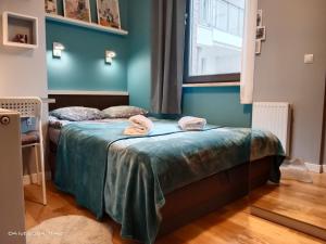 two beds in a room with blue walls at Uroczy Apartament Długie Ogrody 48 in Gdańsk