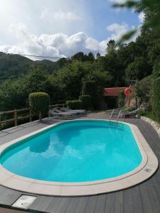 einen großen blauen Pool auf einer Holzterrasse in der Unterkunft Casa de Férias do Parque da Peneda Gerês in Vila Verde