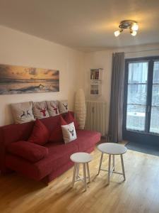 a living room with a red couch and two tables at Ferienwohnung Carpe Diem - a89500 in Walchensee