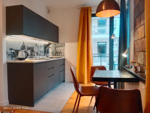 a kitchen with a table and a dining room at Uroczy Apartament Długie Ogrody 48 in Gdańsk