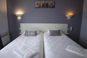 A bed or beds in a room at Hôtel des Dunes Noirmoutier