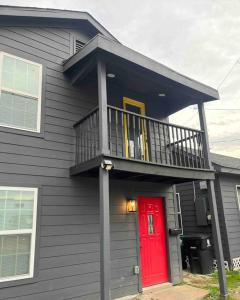 une maison avec une porte rouge et un balcon dans l'établissement Quaint 1 bd close to downtown, à Houston