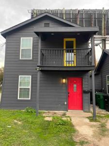 une maison avec une porte rouge et un balcon dans l'établissement Quaint 1 bd close to downtown, à Houston