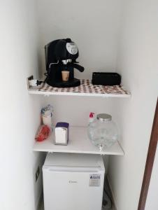 a shelf with a coffee maker on top of a refrigerator at La Cameretta in Barisciano