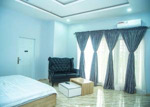 a bedroom with a bed and a black chair at Cis service apartment in Ketti
