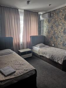 a bedroom with two beds and a window at ЭДЕМ in Taraz