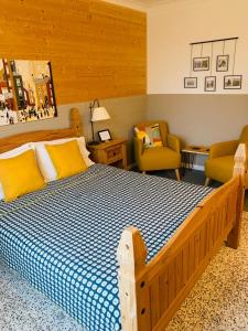 - une chambre avec un grand lit en bois et des oreillers jaunes dans l'établissement La Maison du Canal, à Rostrenen