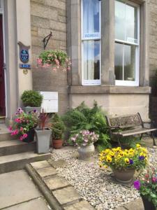 a building with a bunch of potted plants and a bench at Sonas Guesthouse in Edinburgh