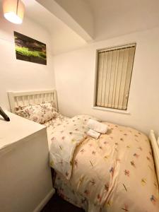 a small bedroom with a bed and a window at Luxurious Suite: Nottingham Room in Nottingham