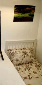 ein Bett mit Kissen und ein Gemälde an der Wand in der Unterkunft Luxurious Suite: Nottingham Room in Nottingham