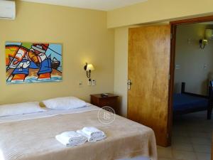 a bedroom with two beds and a painting on the wall at Hotel Aquarella in Punta Del Diablo
