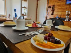 une table avec des assiettes de fruits sur une table dans l'établissement Hostal Casa Arrayán, à Coyhaique