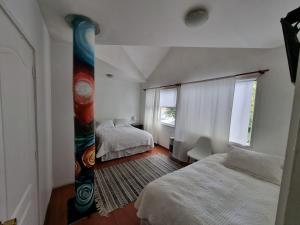 科伊艾科Hostal Casa Arrayán的一间有两张床和一扇大窗户的卧室
