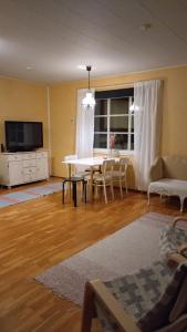 a living room with a table and a tv at Paritalokolmio joen rannalla in Haapavesi