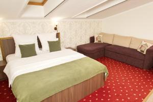 une chambre d'hôtel avec un lit et un canapé dans l'établissement Pensiunea Noblesse, à Băile Felix