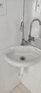 a white sink with a faucet in a bathroom at Solar de Manguinhos Flat in Manguinhos