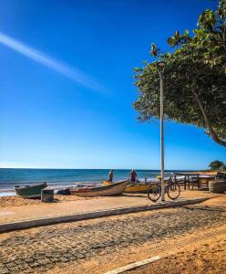 uma bicicleta estacionada ao lado de alguns barcos na praia em Solar de Manguinhos Flat em Manguinhos