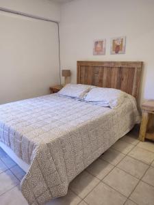 1 dormitorio con 1 cama grande y cabecero de madera en Dpto Catedral en Salta