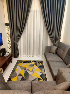 sala de estar con sofá y alfombra en COZY CR Guesthouse Nilai Pajam with Self Check-In en Nilai