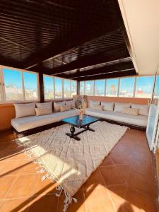 ein Wohnzimmer mit einem Sofa und einem Tisch in der Unterkunft Villa Dune Rouge de la Siesta in Mohammedia