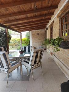 eine Terrasse mit einem Tisch, Stühlen und einer Ziegelwand in der Unterkunft Sueño de Termas in Termas de Río Hondo