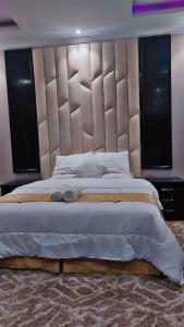 um quarto com uma cama grande e uma grande cabeceira. em درر بيان em Hafr Al-Batin