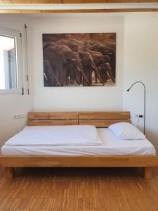 a bed in a room with a picture of elephants at Boardinghouse Steinen in Steinen