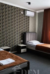 a hotel room with two beds and two tables at ЭДЕМ in Taraz